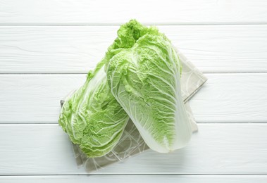 Photo of Fresh Chinese cabbages on white wooden table, top view