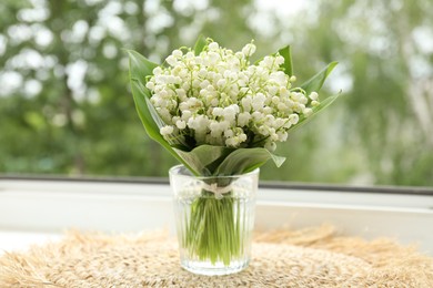 Photo of Bouquet of lily-of-the-valley flowers in vase on windowsill indoors