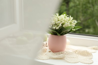 Photo of Bouquet of lily-of-the-valley flowers in vase on windowsill indoors