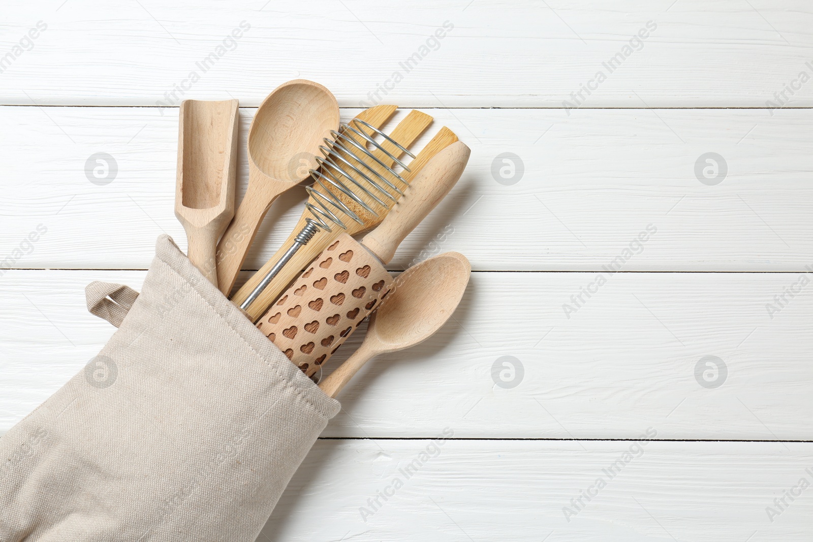 Different kitchen utensils in oven mitten on white wooden table, top view. Space for text Photo of Different kitchen utensils in oven mitten on white wooden table, top view. Space for text