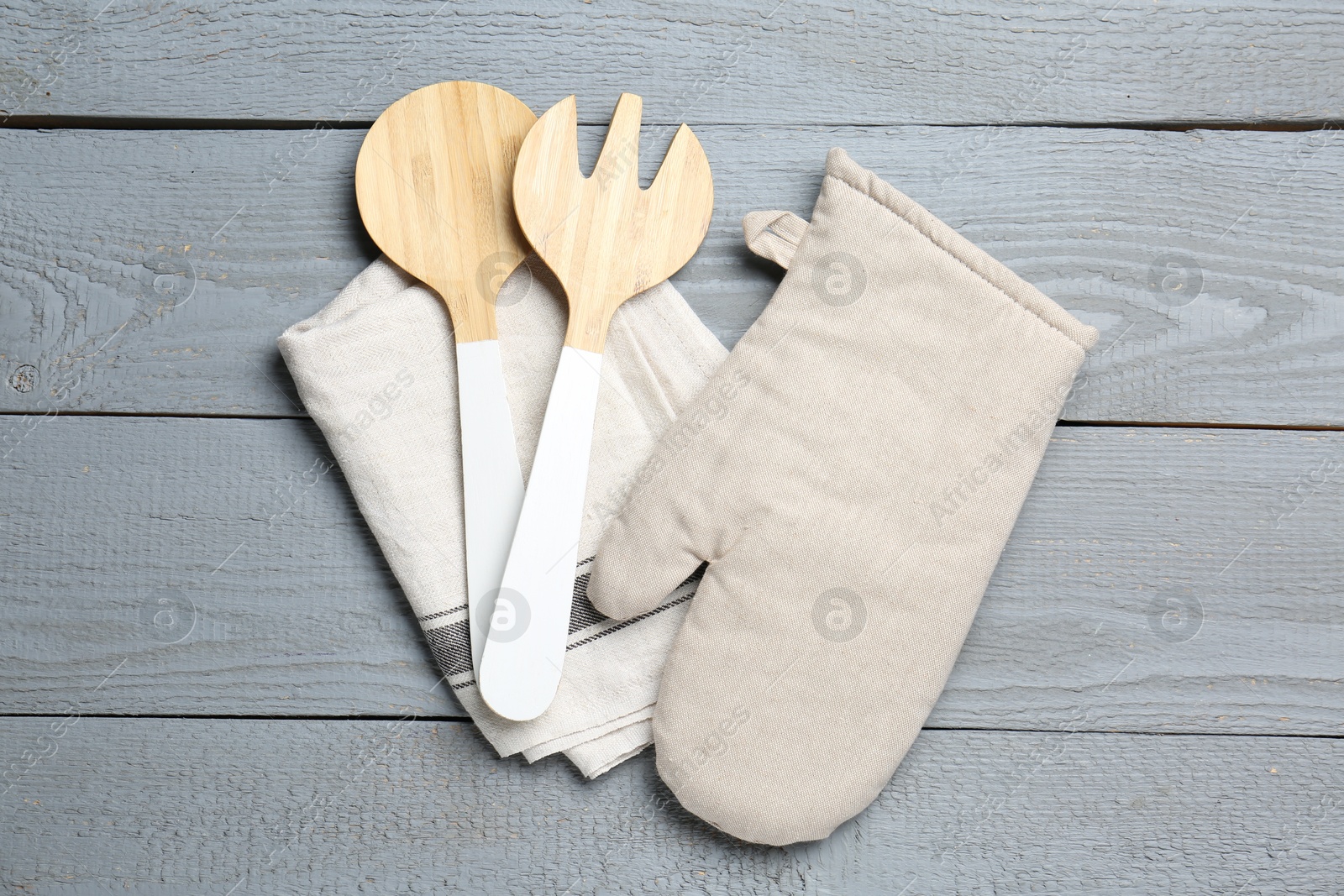 Kitchen utensils and oven mitten on light grey wooden table, top view Photo of Kitchen utensils and oven mitten on light grey wooden table, top view