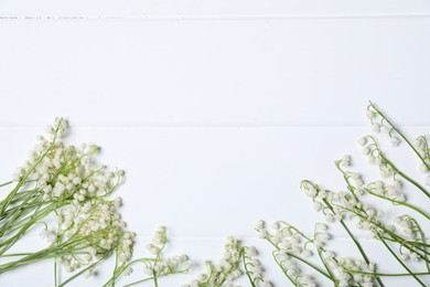 Photo of Beautiful lily-of-the-valley flowers on white wooden background, flat lay. Space for text