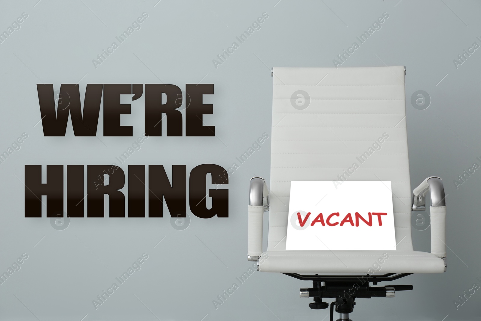 We Are Hiring. Office chair with Vacant sign on grey background. Recruitment, human resources concept Image of We Are Hiring. Office chair with Vacant sign on grey background. Recruitment, human resources concept