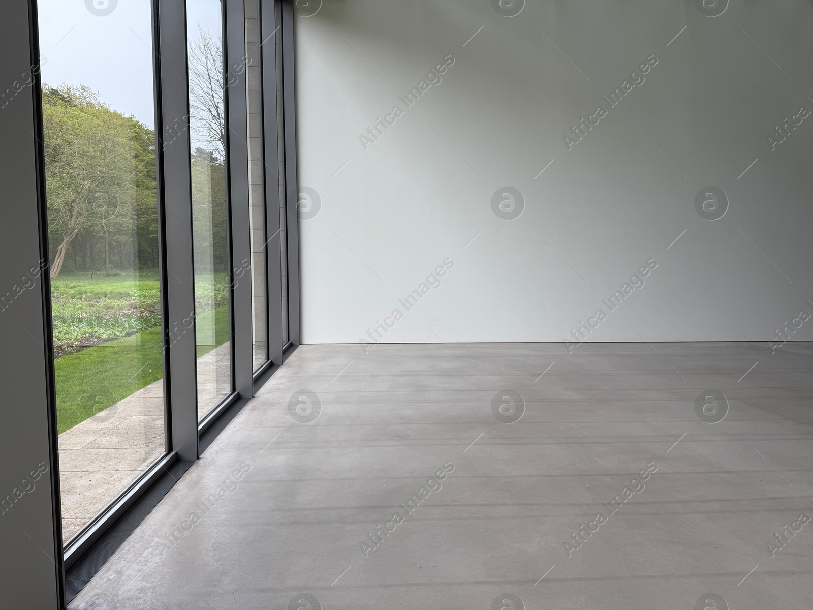 Empty room with panoramic windows and grey floor Photo of Empty room with panoramic windows and grey floor