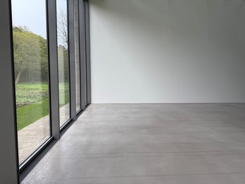 Photo of Empty room with panoramic windows and grey floor