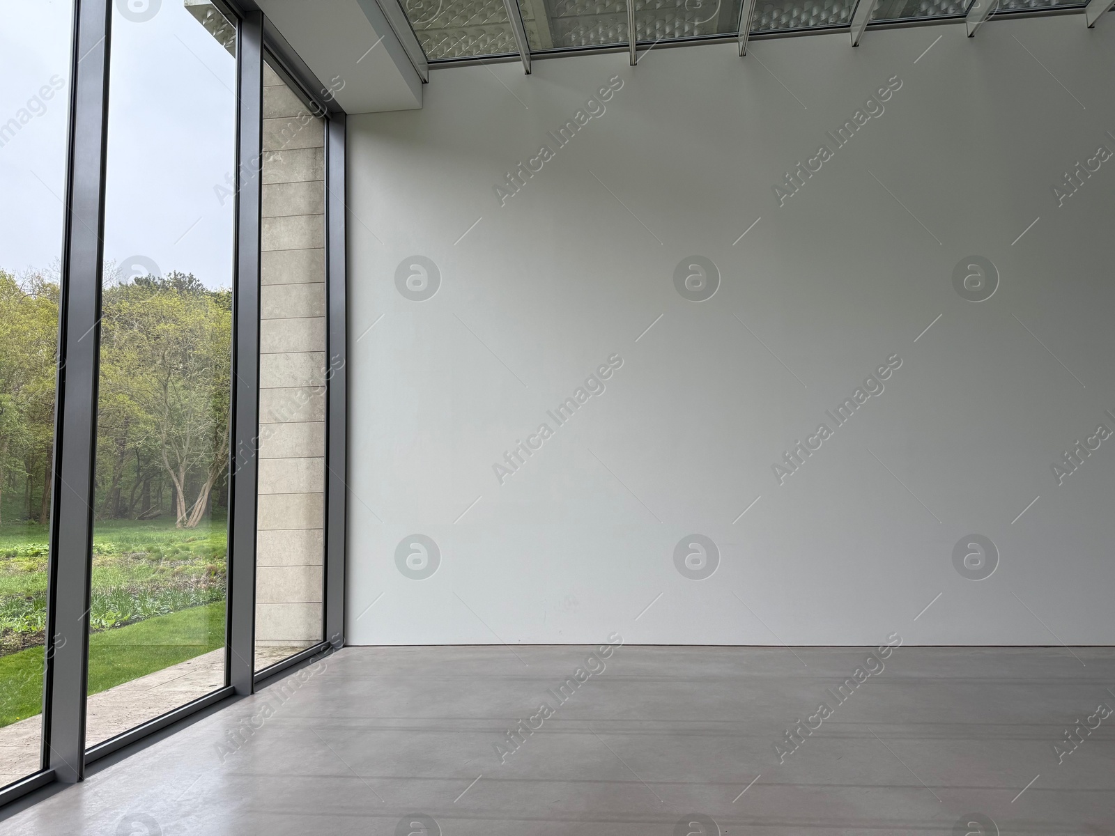 Empty room with panoramic windows and grey floor Photo of Empty room with panoramic windows and grey floor