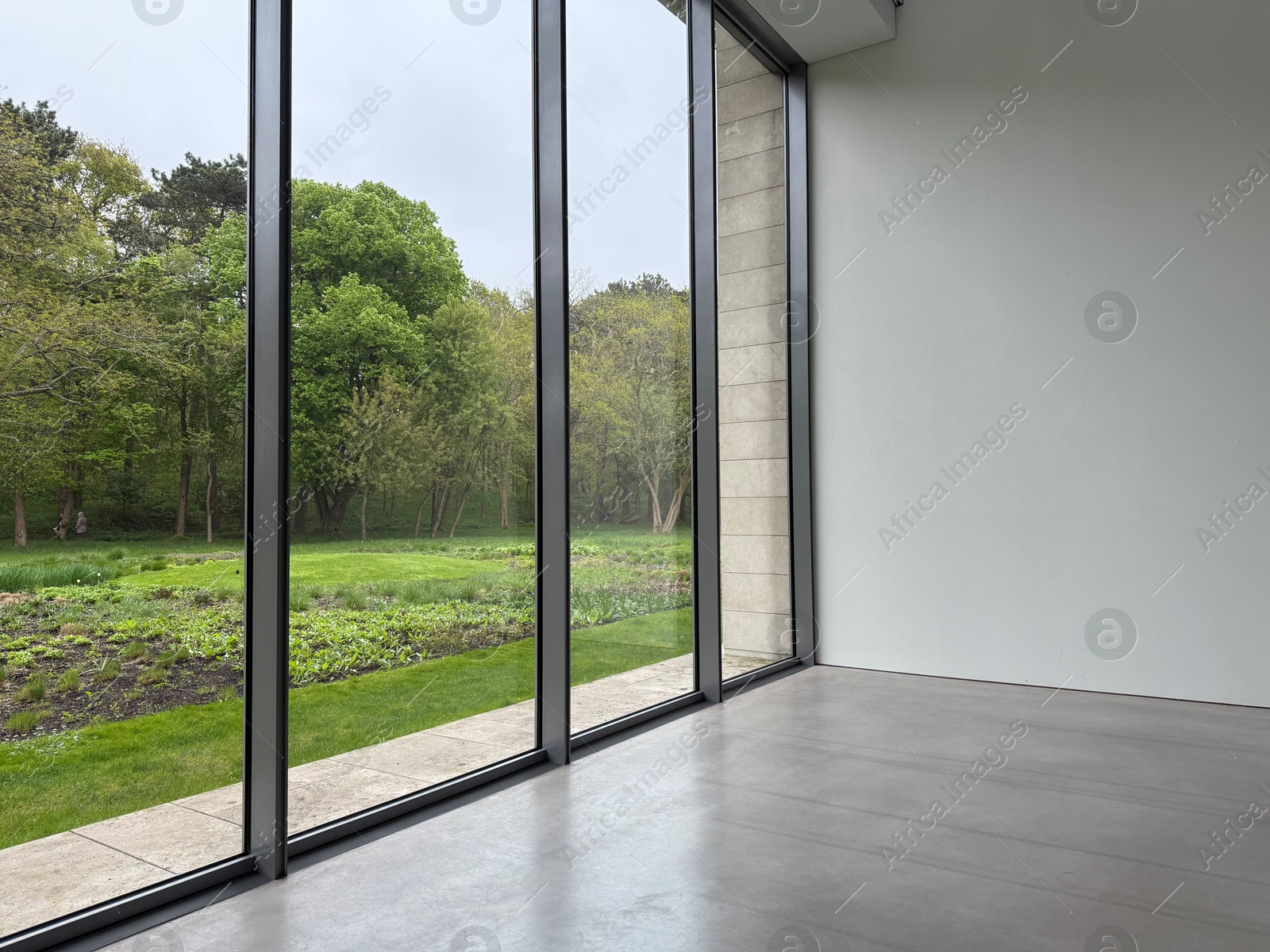 Empty room with panoramic windows and grey floor Photo of Empty room with panoramic windows and grey floor