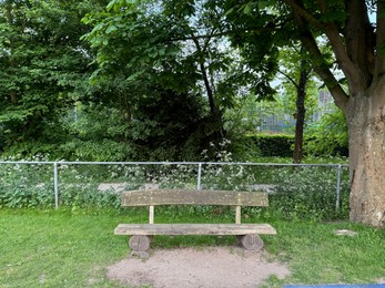Photo of Empty wooden bench near fence in beautiful park