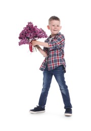 Photo of Little boy with bouquet of lilac flowers on white background