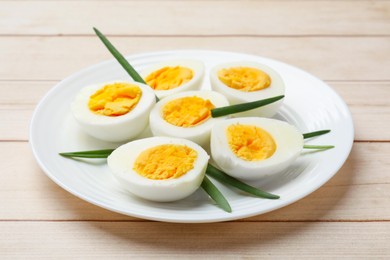 Photo of Boiled eggs and green onions on wooden table, closeup