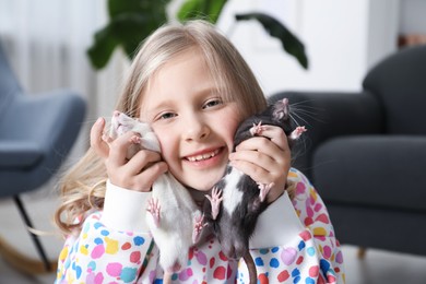 Photo of Little girl with cute rats at home