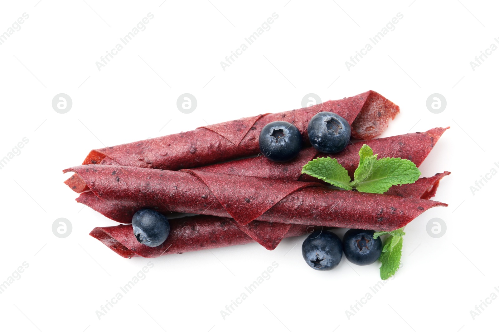 Tasty fruit leather rolls, blueberries and mint isolated on white, top view Photo of Tasty fruit leather rolls, blueberries and mint isolated on white, top view