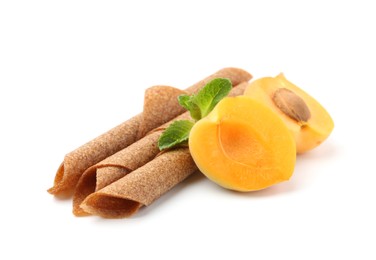 Photo of Tasty fruit leather rolls, apricot and mint isolated on white