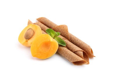 Photo of Tasty fruit leather rolls, apricot and mint isolated on white