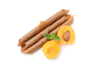 Photo of Tasty fruit leather rolls, apricot and mint isolated on white, top view