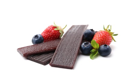 Photo of Tasty fruit leather, strawberries and blueberries isolated on white