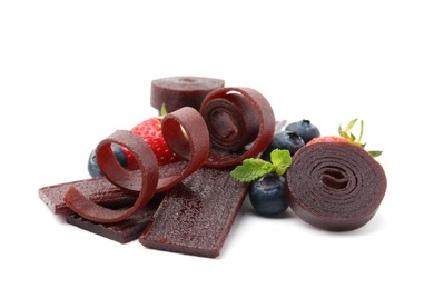 Photo of Tasty fruit leather rolls, strawberries and blueberries isolated on white