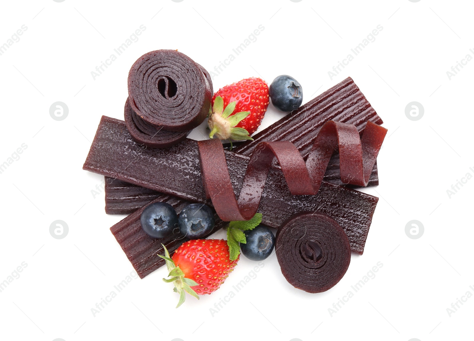 Tasty fruit leather rolls, strawberries and blueberries isolated on white, top view Photo of Tasty fruit leather rolls, strawberries and blueberries isolated on white, top view