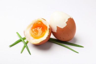 Photo of Soft boiled eggs with green onions on white background
