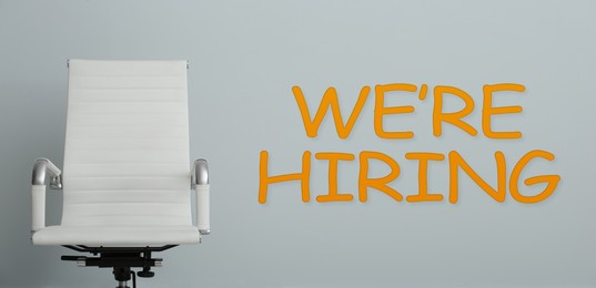 Image of We Are Hiring. Empty office chair on grey background, banner. Recruitment, human resources concept