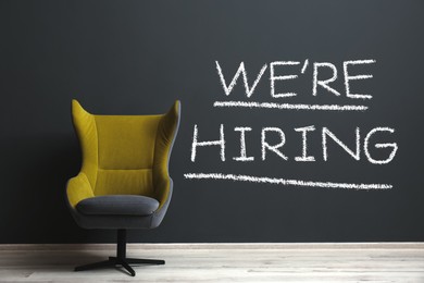 Image of We Are Hiring. Empty office chair near dark wall. Recruitment, human resources concept