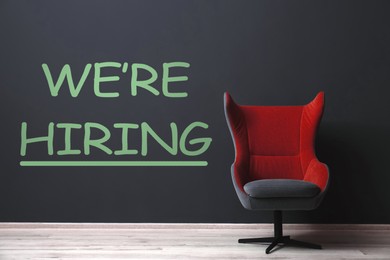 Image of We Are Hiring. Empty office chair near dark wall. Recruitment, human resources concept
