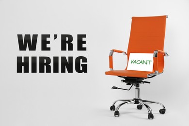 Image of We Are Hiring. Office chair with Vacant sign on light background. Recruitment, human resources concept