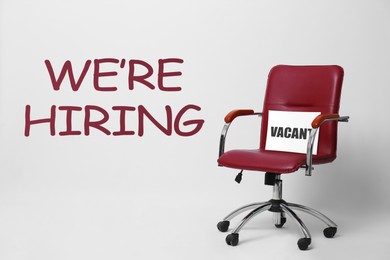 Image of We Are Hiring. Office chair with Vacant sign on light background. Recruitment, human resources concept