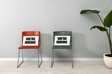 Image of Chairs with We Are Hiring signs indoors. Recruitment, human resources concept