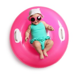 Photo of Cute little baby in sunglasses with inflatable ring on white background, top view