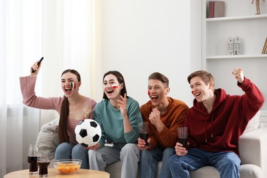 Photo of Emotional football fans watching game together indoors