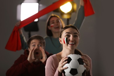 Photo of Emotional sports fans watching game together indoors, selective focus