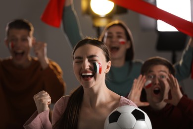 Photo of Emotional sports fans watching game together indoors, selective focus