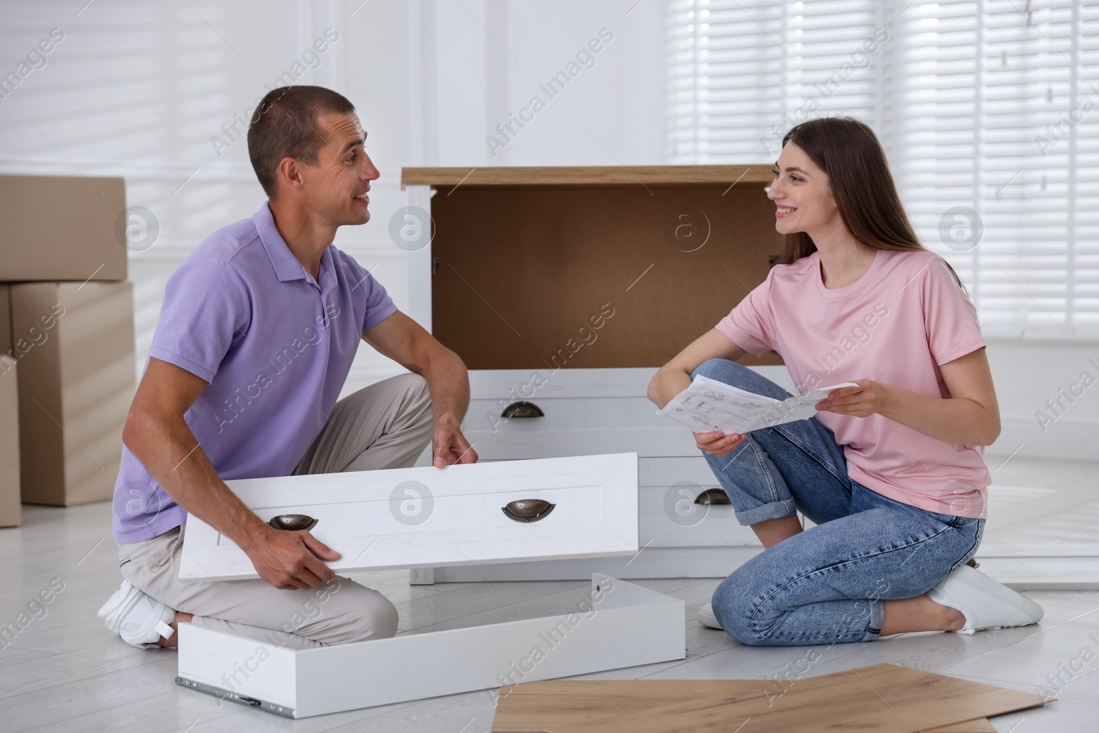Happy couple with manual assembling furniture on floor at home Photo of Happy couple with manual assembling furniture on floor at home
