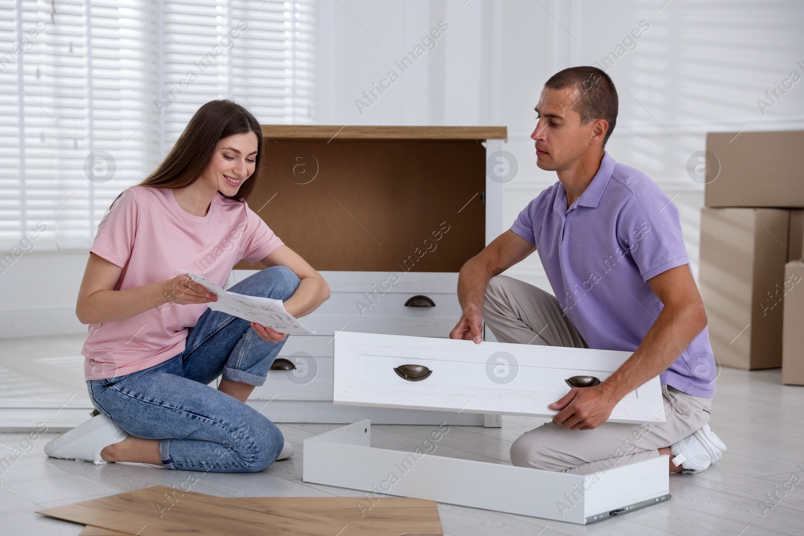 Couple with manual assembling furniture on floor at home Photo of Couple with manual assembling furniture on floor at home