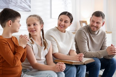 Photo of Family with Bible praying together at home