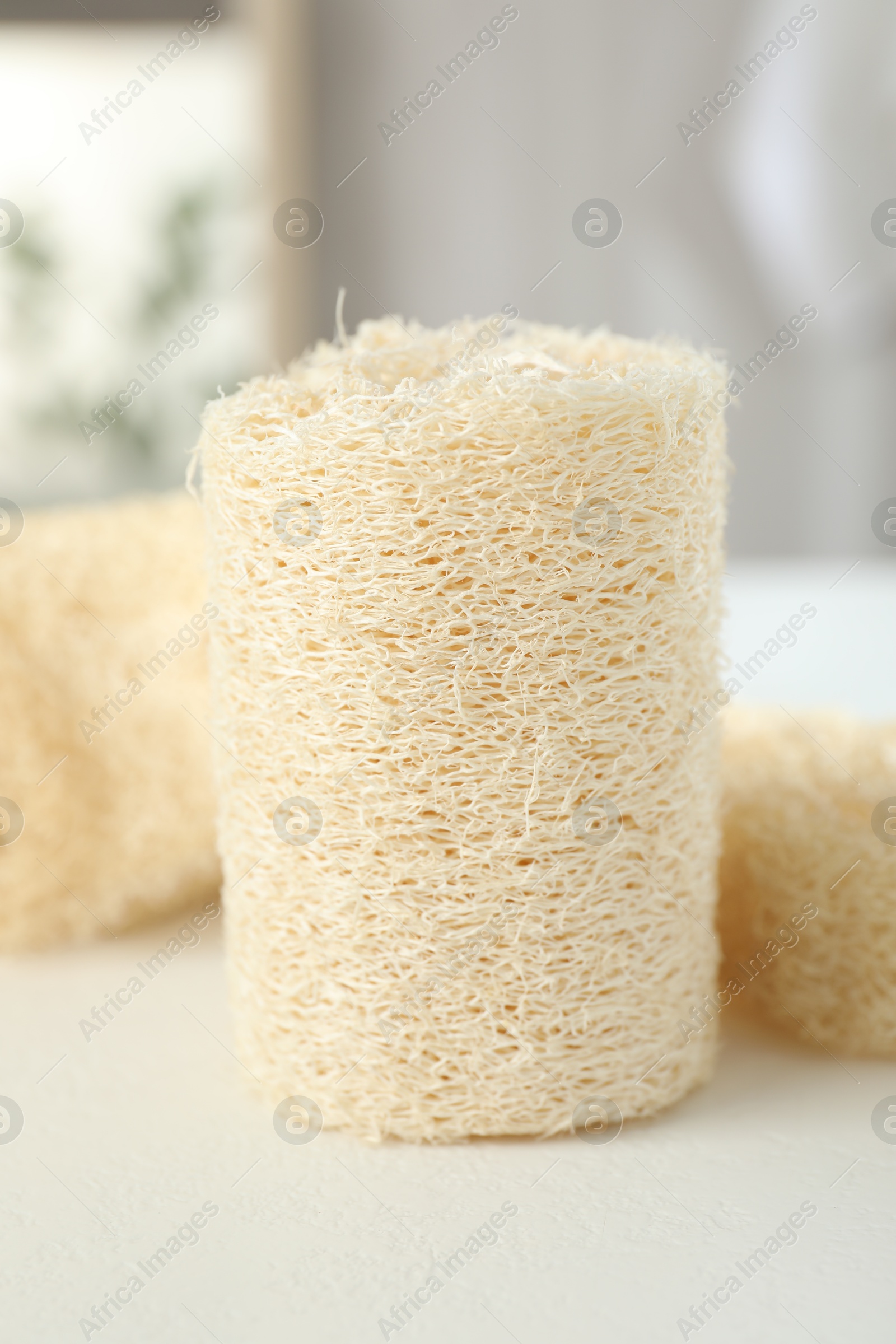 Different loofah sponges on white table, closeup Photo of Different loofah sponges on white table, closeup
