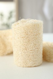 Photo of Different loofah sponges on white table, closeup