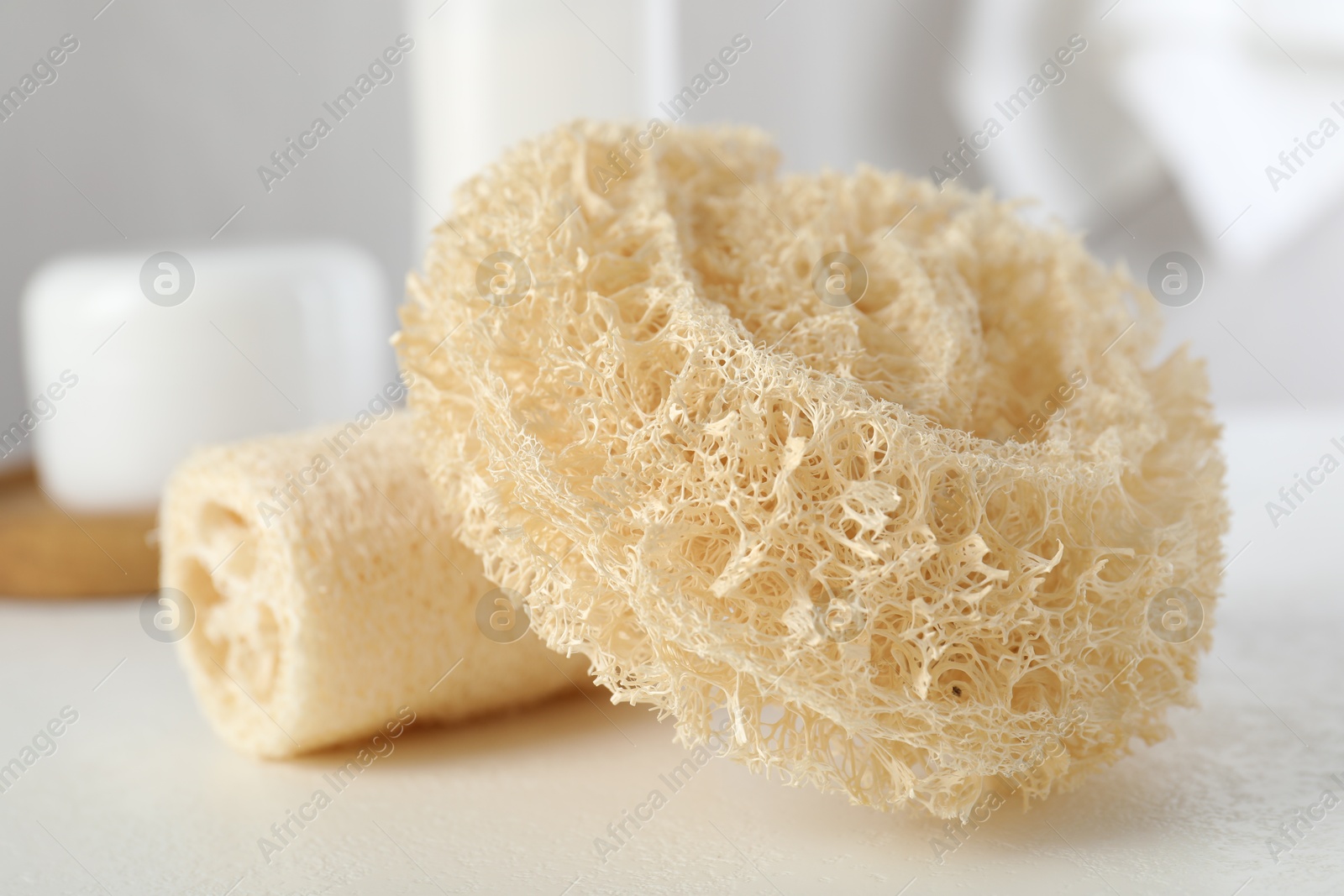 Different loofah sponges on white table, closeup Photo of Different loofah sponges on white table, closeup