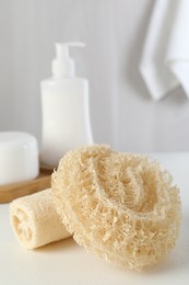 Photo of Different loofah sponges on white table, closeup