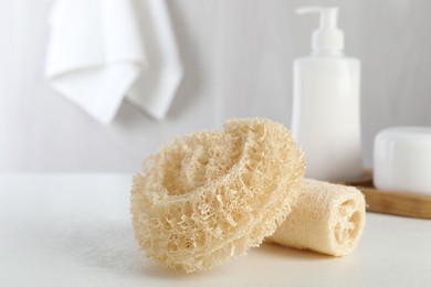 Photo of Different loofah sponges on white table, closeup