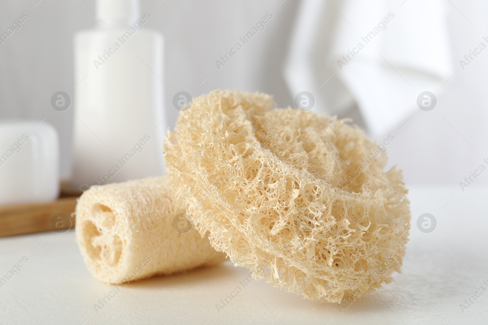 Different loofah sponges on white table, closeup Photo of Different loofah sponges on white table, closeup