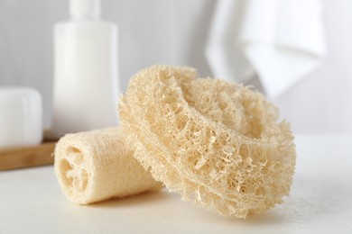 Photo of Different loofah sponges on white table, closeup