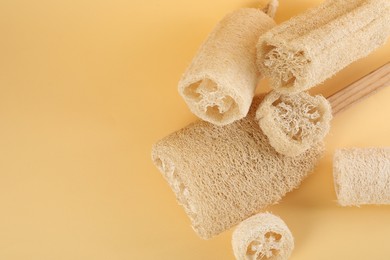 Photo of Different loofah sponges on beige background, flat lay. Space for text