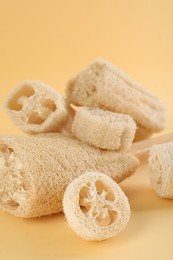 Photo of Different loofah sponges on beige background, closeup