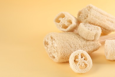 Photo of Different loofah sponges on beige background, closeup. Space for text