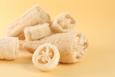Photo of Different loofah sponges on beige background, closeup