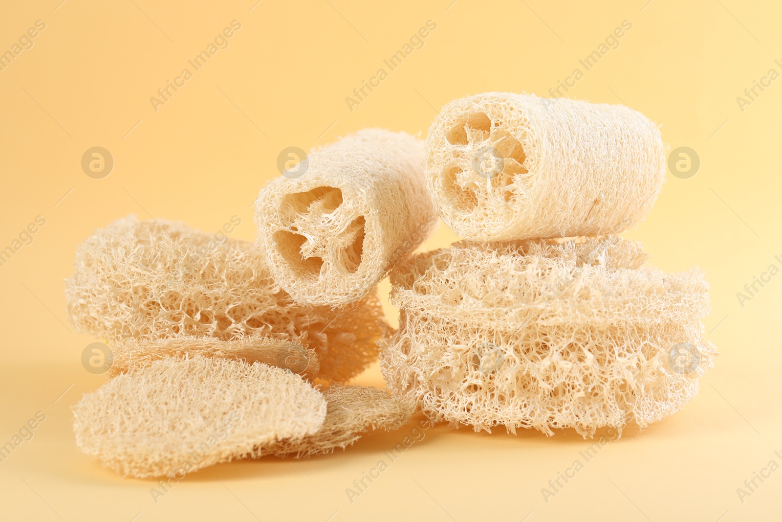 Different loofah sponges on beige background, closeup Photo of Different loofah sponges on beige background, closeup