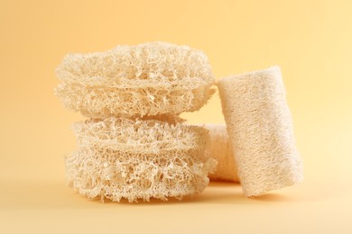 Photo of Different loofah sponges on beige background, closeup