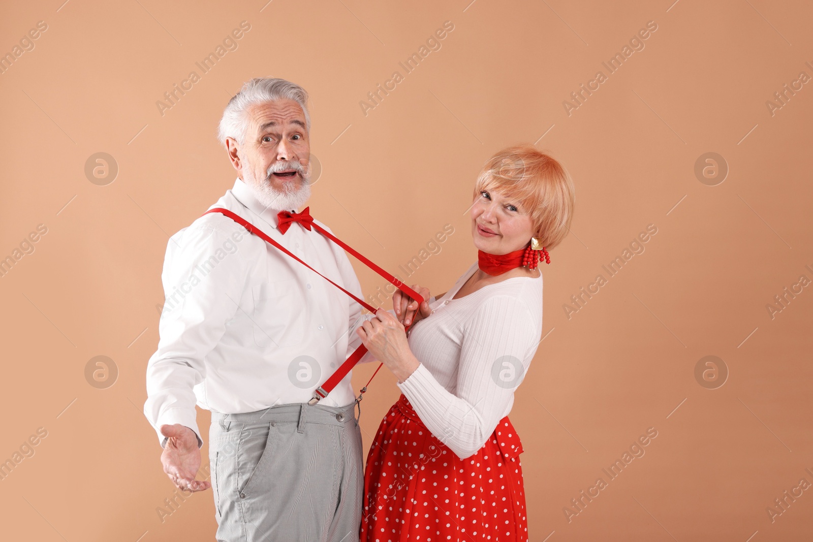 Lovely senior couple together on light brown background Photo of Lovely senior couple together on light brown background